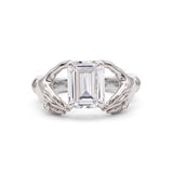 Emerald-cut lab-grown diamond engagement ring with a sculpted gold double-dolphin band and round diamond accents