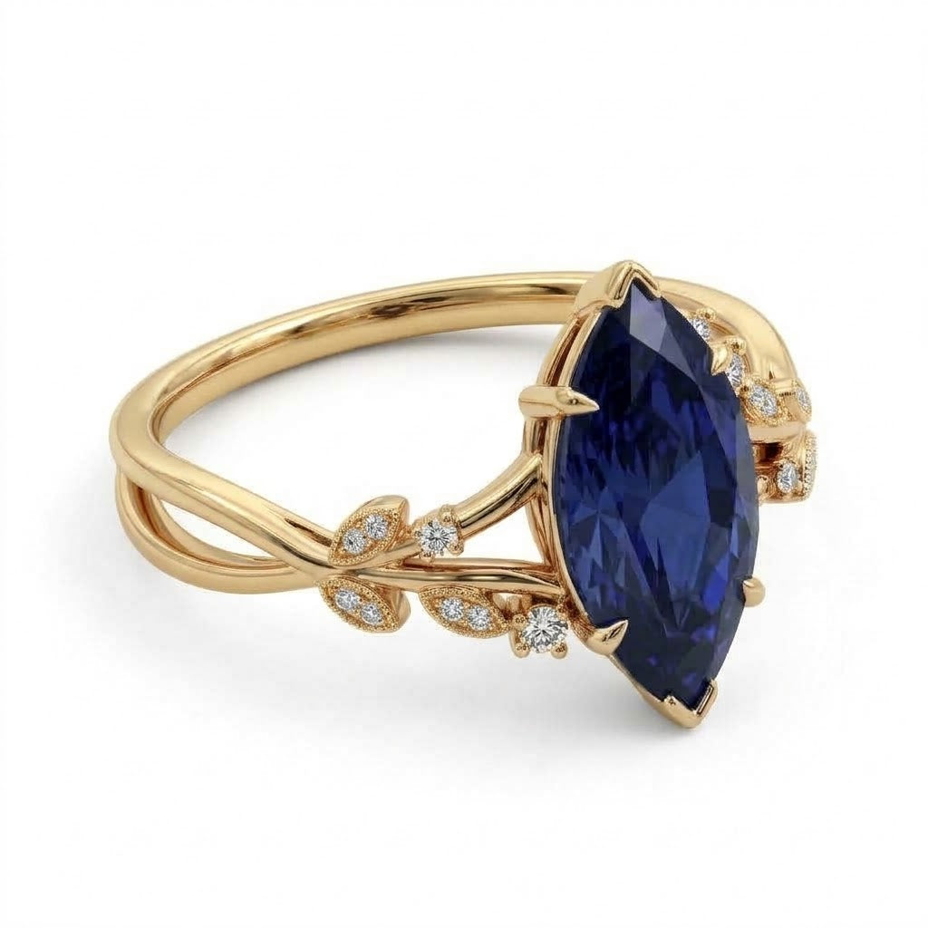 Deep-blue marquise gemstone ring with white-metal split shoulders, sparkling leaf-shaped settings and scattered round accents