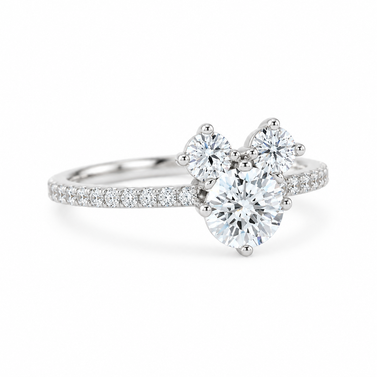 A silver-tone cluster ring featuring a large round center diamond flanked by two smaller round diamonds, with a pavé band set with additional small diamonds, shown on a clean white background.