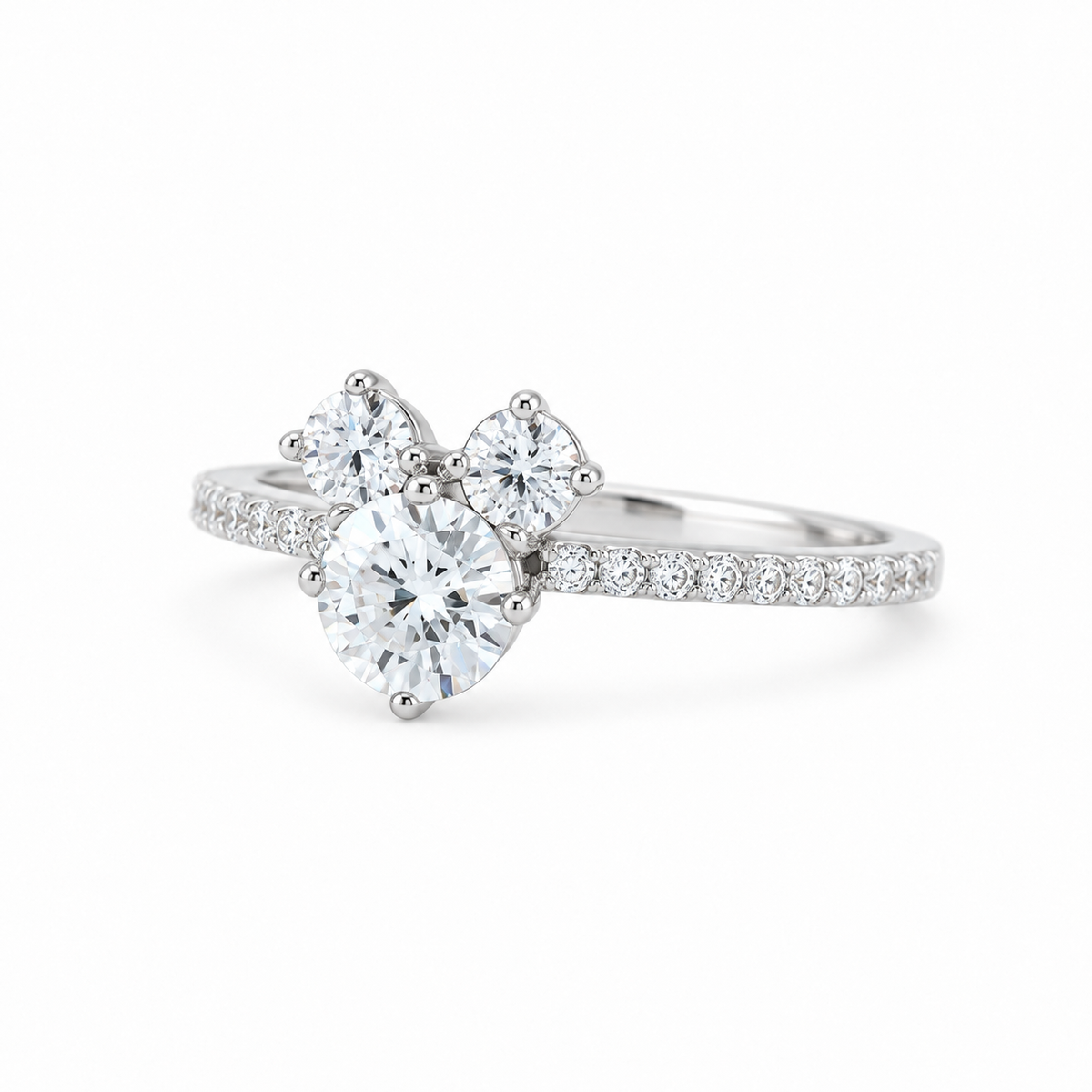 A silver-tone diamond ring featuring a large pear-cut center stone with three smaller heart-shaped stones above it, accented by pavé diamonds along the band, set against a clean white background.