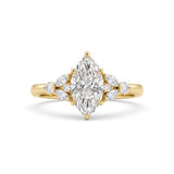 A yellow gold ring featuring a large marquise-cut center diamond flanked by smaller round and marquise diamonds on the shoulders, set against a clean white background.