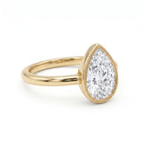 Pear-cut lab-grown diamond bezel solitaire engagement ring with fine milgrain detailing and a polished yellow-gold band.