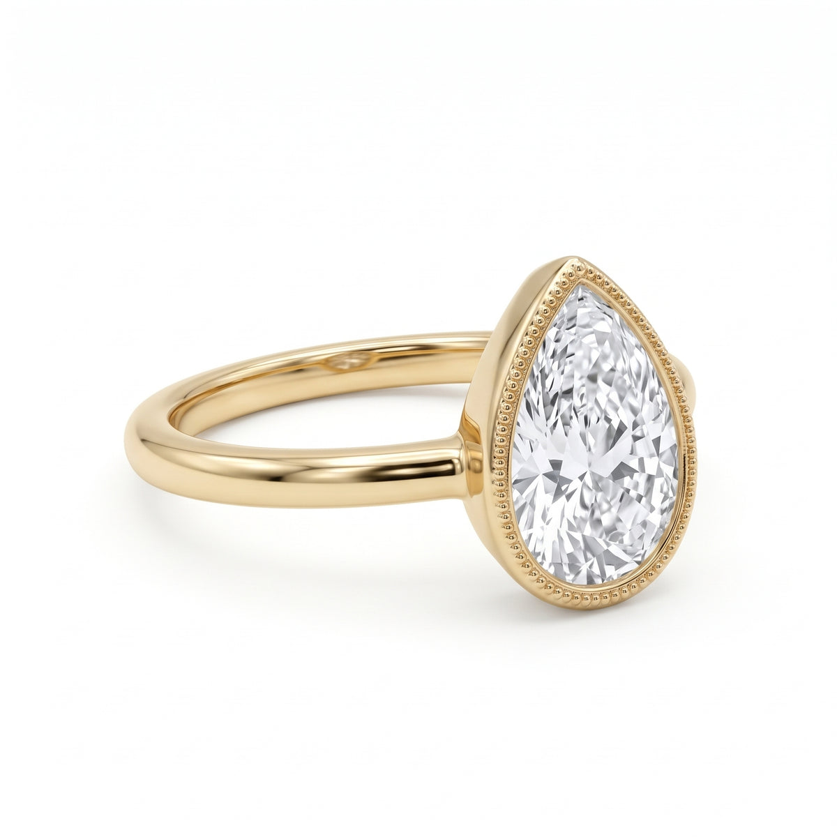 Pear-cut lab-grown diamond bezel solitaire engagement ring with fine milgrain detailing and a polished yellow-gold band.