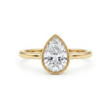 Pear-cut lab-grown diamond bezel solitaire engagement ring with fine milgrain detailing and a polished yellow-gold band.