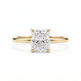 Elongated radiant-cut lab-grown diamond solitaire engagement ring with four prongs and a polished yellow-gold band.