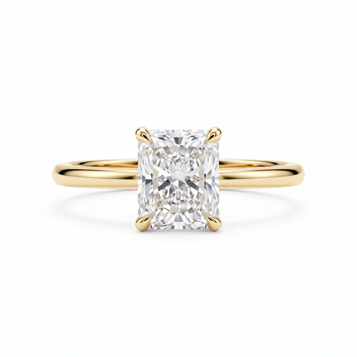 Elongated radiant-cut lab-grown diamond solitaire engagement ring with four prongs and a polished yellow-gold band.