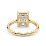 Elongated radiant-cut lab-grown diamond solitaire engagement ring with four prongs and a polished yellow-gold band.