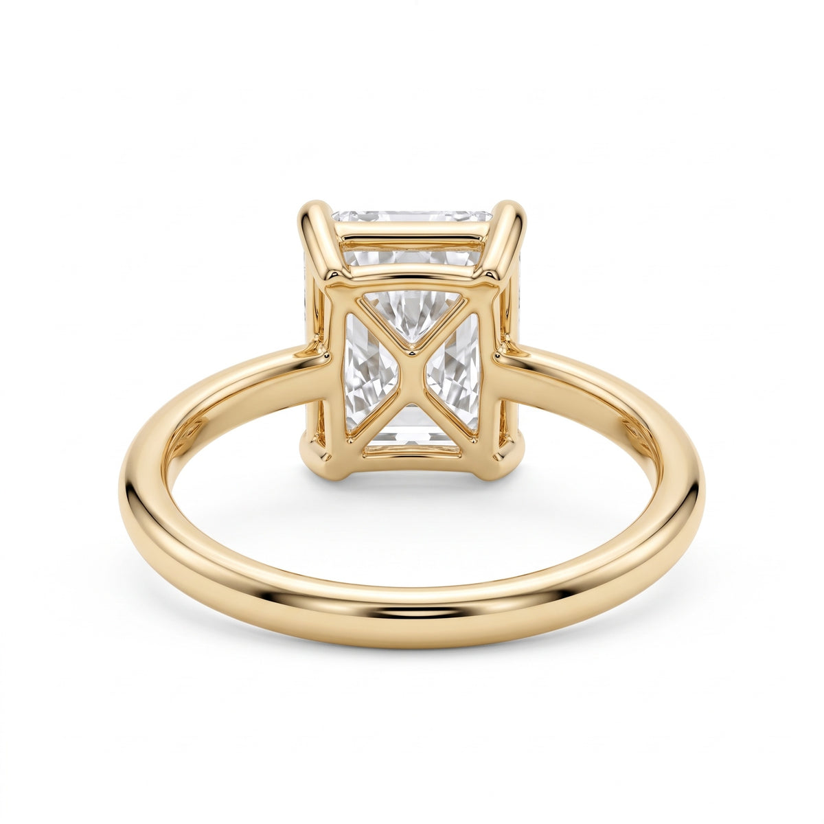 Elongated radiant-cut lab-grown diamond solitaire engagement ring with four prongs and a polished yellow-gold band.