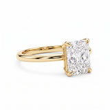 Elongated radiant-cut lab-grown diamond solitaire engagement ring with four prongs and a polished yellow-gold band.