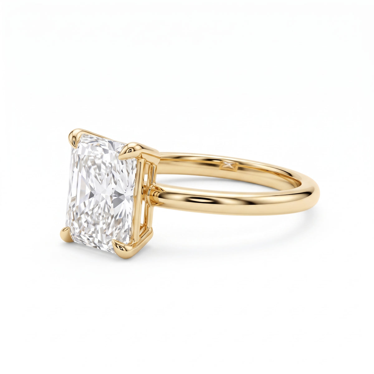 Elongated radiant-cut lab-grown diamond solitaire engagement ring with four prongs and a polished yellow-gold band.