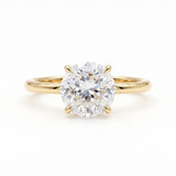 Round Portuguese-cut lab-grown diamond solitaire engagement ring with a four-prong setting and polished yellow-gold band.