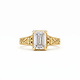 Vintage emerald-cut lab-grown diamond engagement ring with floral filigree, leaf engraving and milgrain detailing in polished yellow gold.