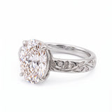 Oval-cut lab-grown diamond botanical engagement ring with leaf and vine band