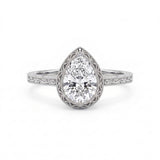 Vintage pear-cut lab-grown diamond bezel engagement ring with milgrain detailing and an engraved yellow-gold filigree band.