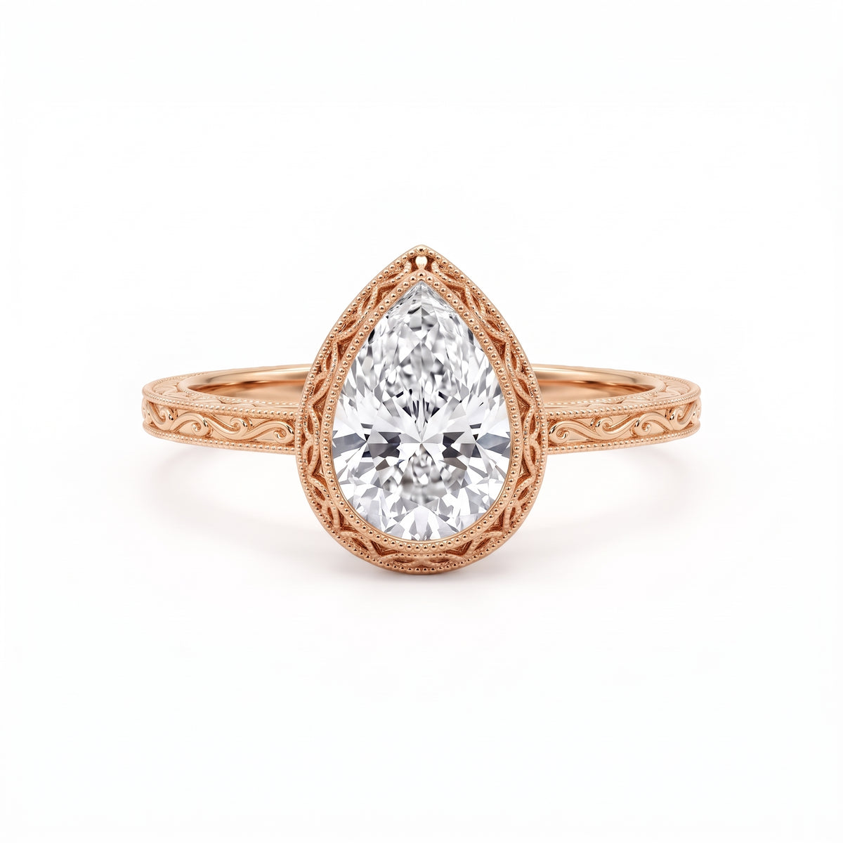 Vintage pear-cut lab-grown diamond bezel engagement ring with milgrain detailing and an engraved yellow-gold filigree band.