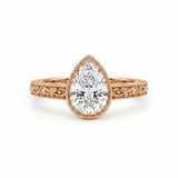 Vintage pear-cut lab-grown diamond bezel engagement ring with milgrain, scroll filigree and round diamond accents on a yellow-gold band.