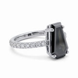 Black coffin-shaped gemstone engagement ring with four polished prongs and round clear accents along a white-metal band