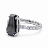Black coffin-shaped gemstone engagement ring with four polished prongs and round clear accents along a white-metal band
