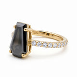 Black coffin-shaped gemstone engagement ring with four polished prongs and round clear accents along a white-metal band