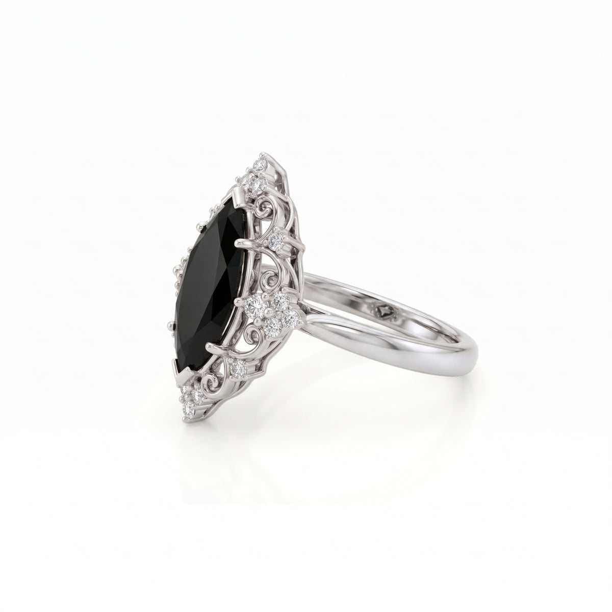 Black marquise gemstone ring with ornate white-metal scrollwork, clear round accent clusters and a polished band