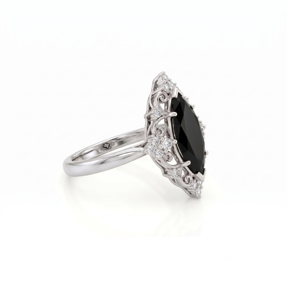 Black marquise gemstone ring with ornate white-metal scrollwork, clear round accent clusters and a polished band