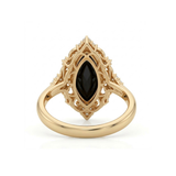 Black marquise gemstone ring with ornate white-metal scrollwork, clear round accent clusters and a polished band