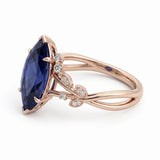 Deep-blue marquise gemstone ring with white-metal split shoulders, sparkling leaf-shaped settings and scattered round accents