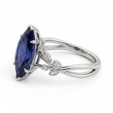 Deep-blue marquise gemstone ring with white-metal split shoulders, sparkling leaf-shaped settings and scattered round accents
