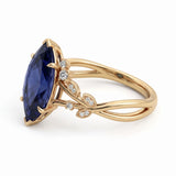 Deep-blue marquise gemstone ring with white-metal split shoulders, sparkling leaf-shaped settings and scattered round accents