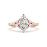 A rose gold engagement ring featuring a marquise-cut center diamond surrounded by smaller round and marquise diamonds on the band, set against a clean white background.