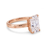 Radiant-cut solitaire engagement ring with four claw prongs and daisy flower engravings on a polished white-metal band