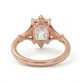 Radiant-cut engagement ring with pear-shaped accents above and below the center stone, pavé diamonds and polished white-metal split shoulders