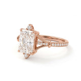 Radiant-cut engagement ring with pear-shaped accents above and below the center stone, pavé diamonds and polished white-metal split shoulders