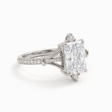 Radiant-cut engagement ring with pear-shaped accents above and below the center stone, pavé diamonds and polished white-metal split shoulders