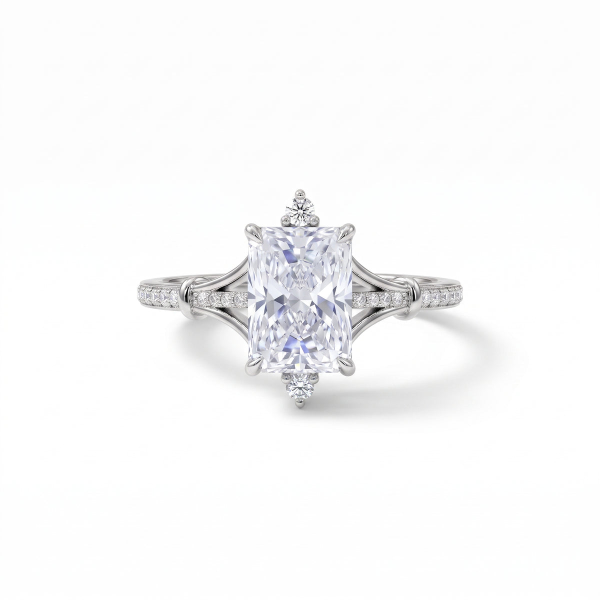 Radiant-cut engagement ring with pear-shaped accents above and below the center stone, pavé diamonds and polished white-metal split shoulders