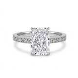 Radiant-cut solitaire engagement ring with four claw prongs, floral scroll engravings and milgrain borders on a white-metal band