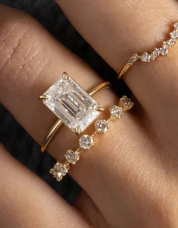 Emerald-cut diamond ring stacked with diamond eternity band