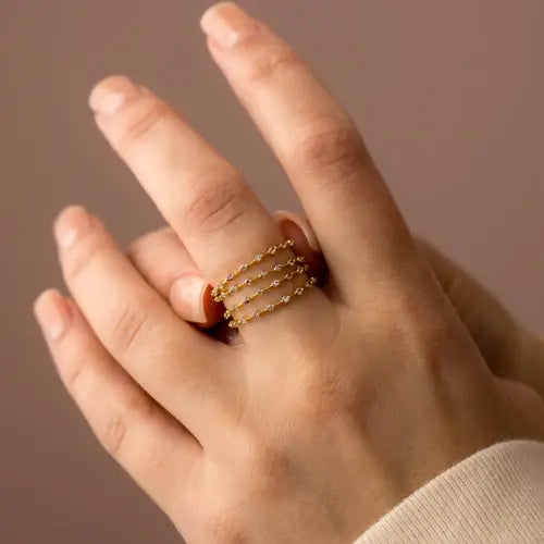 Layered gold chain-link ring on finger