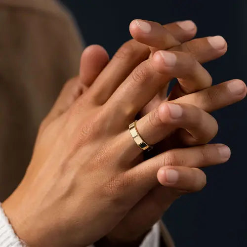 Men's gold wedding band worn while holding hands