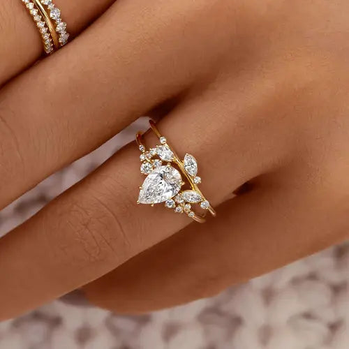 Pear-shaped diamond ring stacked with marquise diamond band, gold